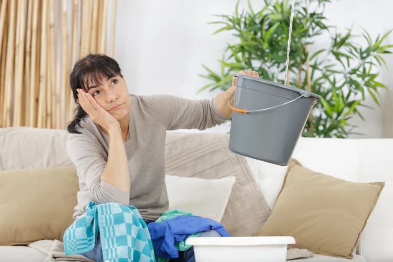 homeowner holding bucket for the leak -water leaking from ceiling