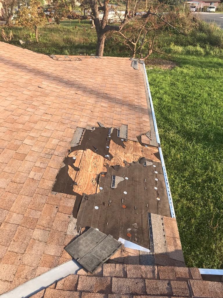 Damaged roof with missing shingles.