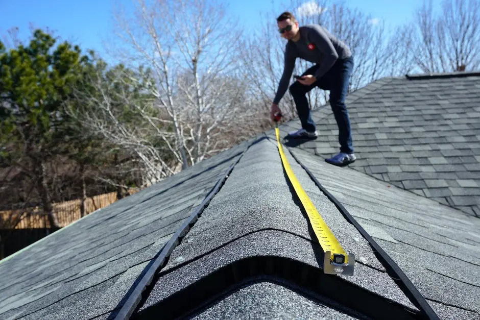 man measuring roof for tarp - how to tarp a roof